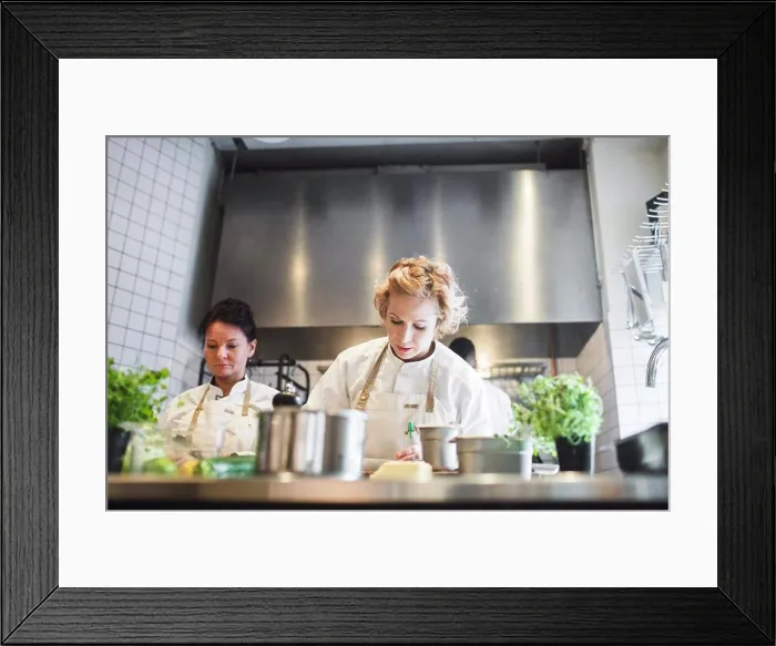 Framed Print : Low angle view of female chefs working at kitchen counter in restaurant Framed Print : Low angle view of female chefs working at kitchen counter in restaurant