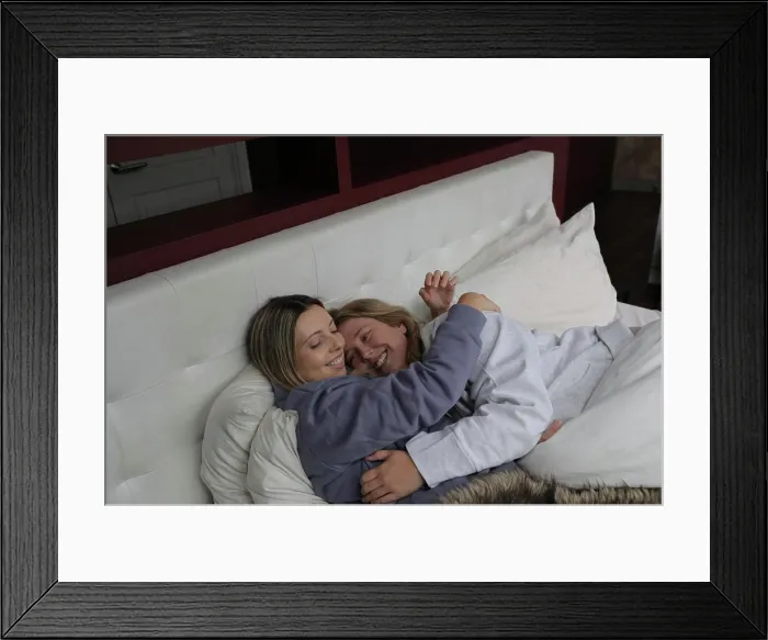 Framed Print : Lesbian couple embracing in bed Framed Print : Lesbian couple embracing in bed