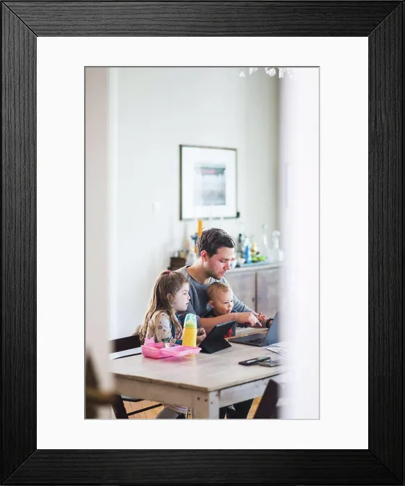 Framed Print : Father using laptop while sitting with cute children at table