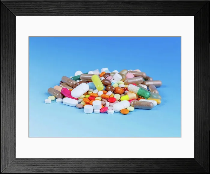 Framed Print : Pile of pills against a blue background Framed Print : Pile of pills against a blue background