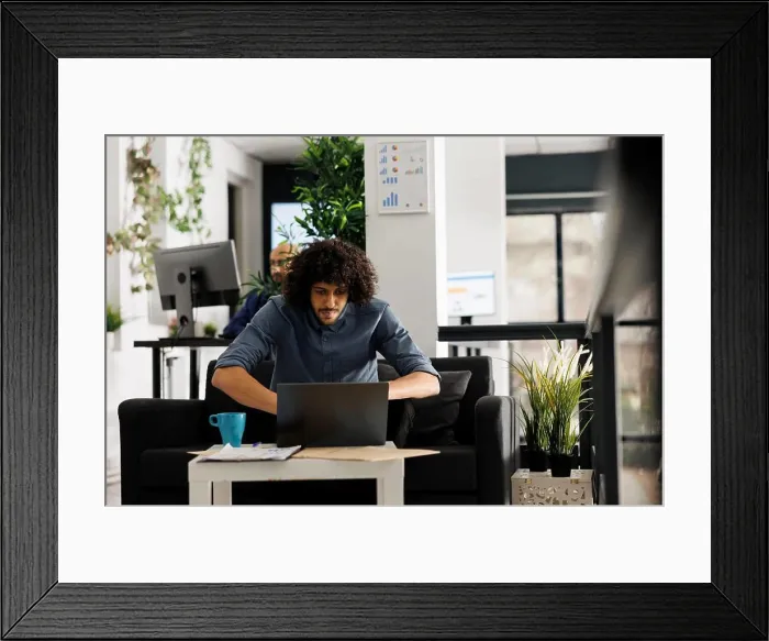 Framed Print : Young arab entrepreneur analyzing company sales statistics on laptop Framed Print : Young arab entrepreneur analyzing company sales statistics on laptop