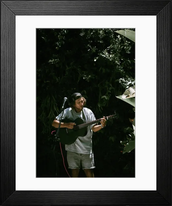 Framed Print : Young man singer, sings into a microphone and plays the guitar Framed Print : Young man singer, sings into a microphone and plays the guitar