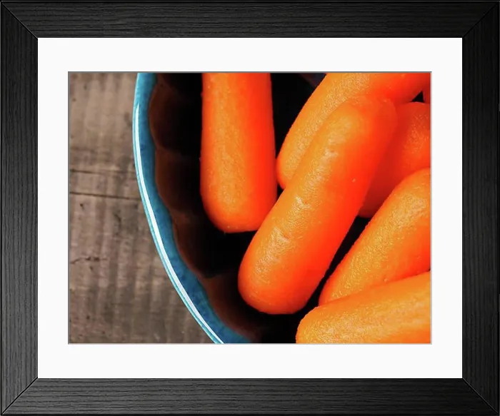 Framed Print : Small baby carrots in a rustic blue ceramic bowl, close up shot Framed Print : Small baby carrots in a rustic blue ceramic bowl, close up shot