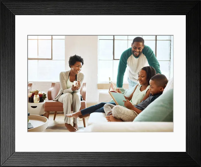 Framed Print : Black family, reading book and children on couch in home Framed Print : Black family, reading book and children on couch in home
