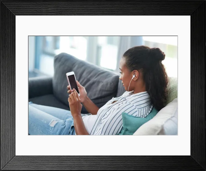 Framed Print : Woman, smartphone and home on couch with earphones Framed Print : Woman, smartphone and home on couch with earphones