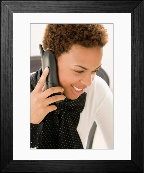 Framed Print : Close-up of a businesswoman talking on a cordless phone and smiling Framed Print : Close-up of a businesswoman talking on a cordless phone and smiling