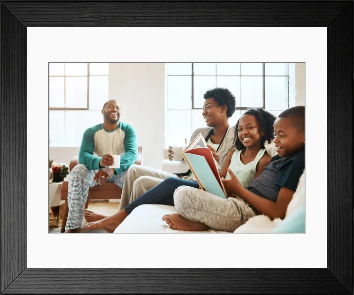 Framed Print : Black family, reading book and children on sofa