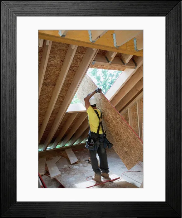 Framed Print : Carpenter lifting a roof panel at a construction site Framed Print : Carpenter lifting a roof panel at a construction site