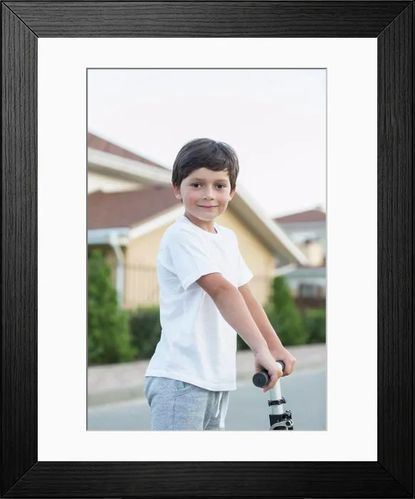 Framed Print : Portrait of boy with push scooter in town