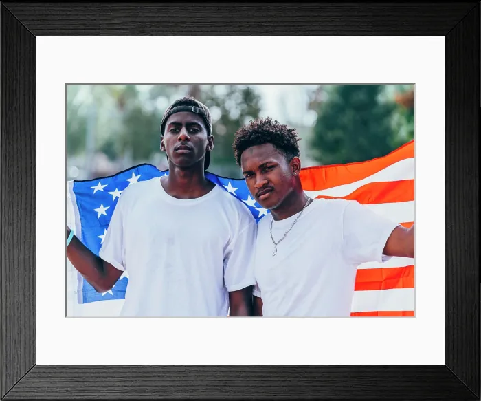Framed Print : Serious African American men holding American flag on shoulder and looking away