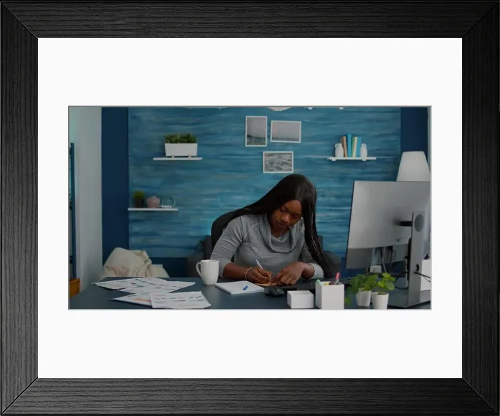 Framed Print : Black student writing school ideas on stickey notes working at homework sitting at desk table Framed Print : Black student writing school ideas on stickey notes working at homework sitting at desk table