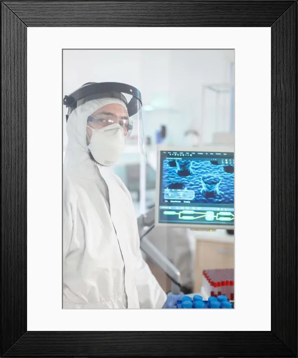 Framed Print : Microbiologist in ppe suit standing in laboratory looking at camera Framed Print : Microbiologist in ppe suit standing in laboratory looking at camera