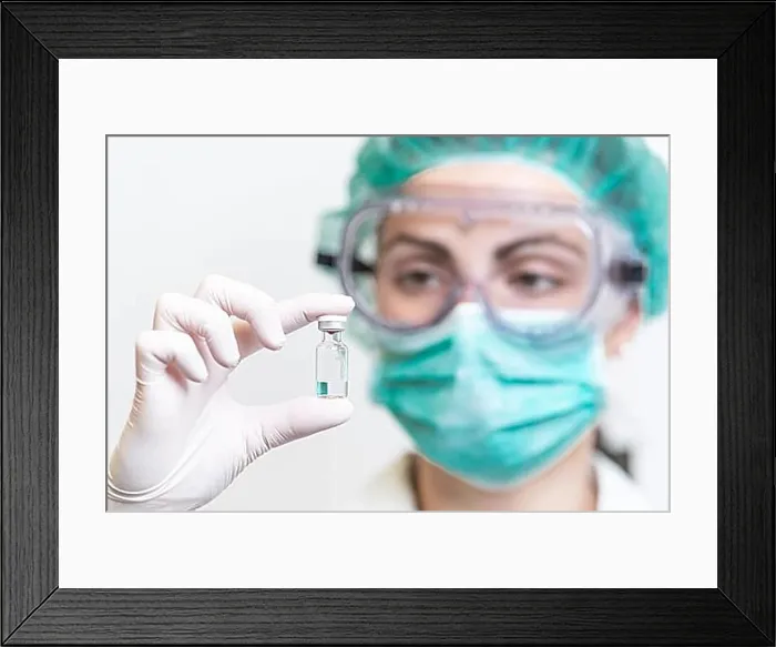 Framed Print : Doctor or nurse in protective gloves holding vaccine vial for Coronavirus outbreak pandemic. Medicine and drug concept