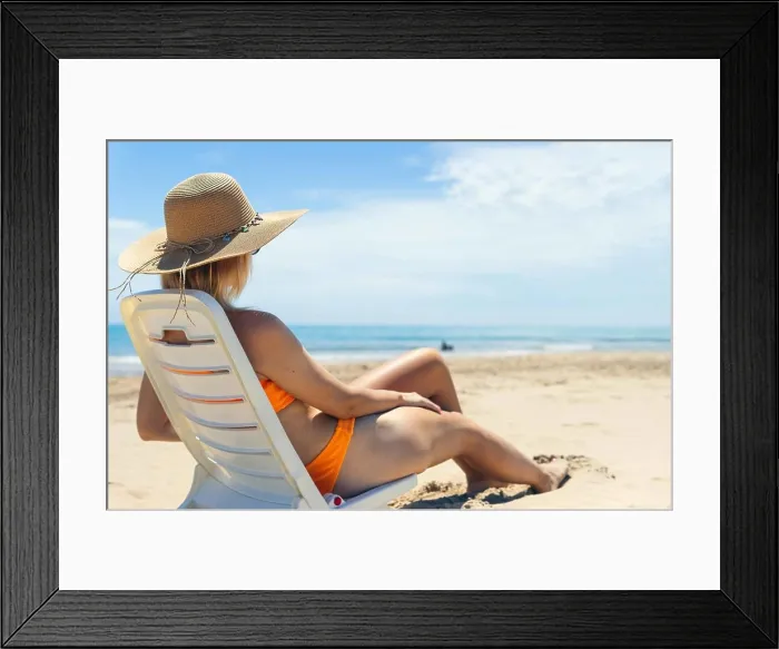 Framed Print : sexy tanned girl is sitting on a sun lounger in an orange swimsuit and a brown hat, her back is Framed Print : sexy tanned girl is sitting on a sun lounger in an orange swimsuit and a brown hat, her back is