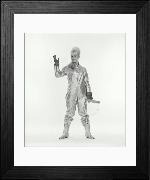 Framed Print : Studio portrait of young female astronaut holding space helmet Framed Print : Studio portrait of young female astronaut holding space helmet