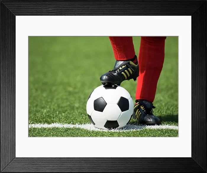 Framed Print : Feet of a football player in red socks and a classic black-and-white football Framed Print : Feet of a football player in red socks and a classic black-and-white football
