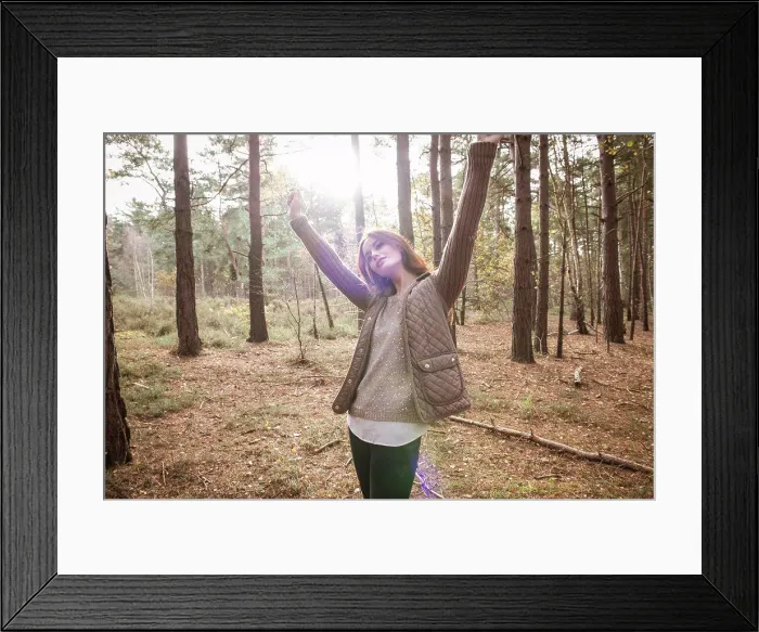 Framed Print : A young woman communing with nature in a forest in Autumn