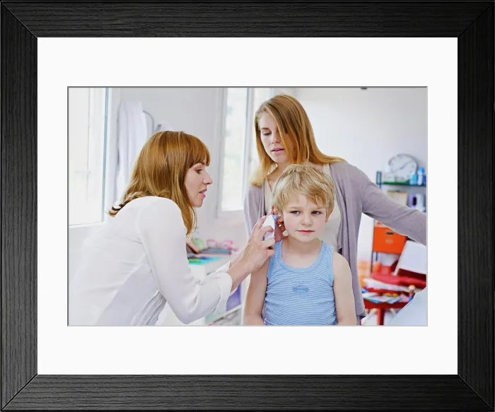 Framed Print : Doctor measuring a child's temperature