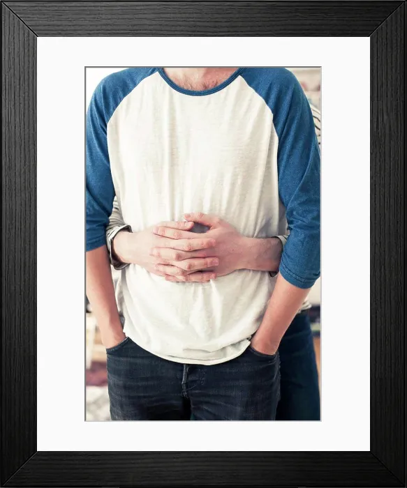 Framed Print : Midsection of gay man embracing partner from behind at home Framed Print : Midsection of gay man embracing partner from behind at home