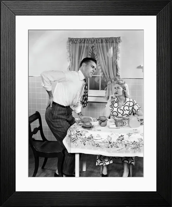 Framed Print : 1950s COUPLE AT BREAKFAST TABLE MAN WITH HAND ON HIP SUFFERING BACK PAIN Framed Print : 1950s COUPLE AT BREAKFAST TABLE MAN WITH HAND ON HIP SUFFERING BACK PAIN