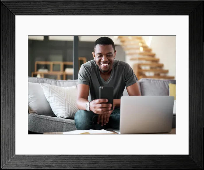 Framed Print : Laptop, phone and man on sofa for remote work Framed Print : Laptop, phone and man on sofa for remote work