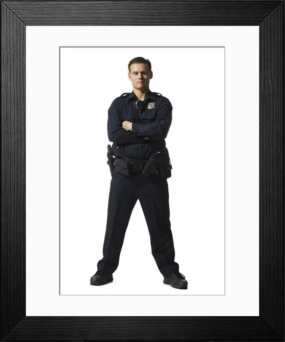 Framed Print : Male police officer standing with arms crossed