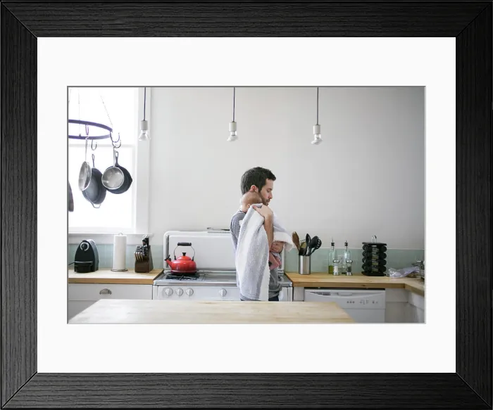 Framed Print : Father comforting toddler in a cozy kitchen setting Framed Print : Father comforting toddler in a cozy kitchen setting