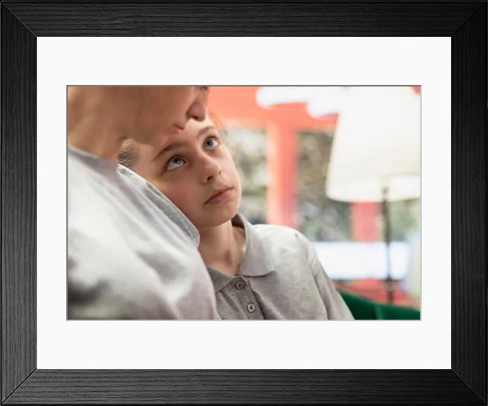 Framed Print : Teen girl cuddling with her mother after solving conflict in therapy session Framed Print : Teen girl cuddling with her mother after solving conflict in therapy session