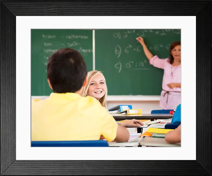 Framed Print : Schoolgirl turning around to her classmates during the class