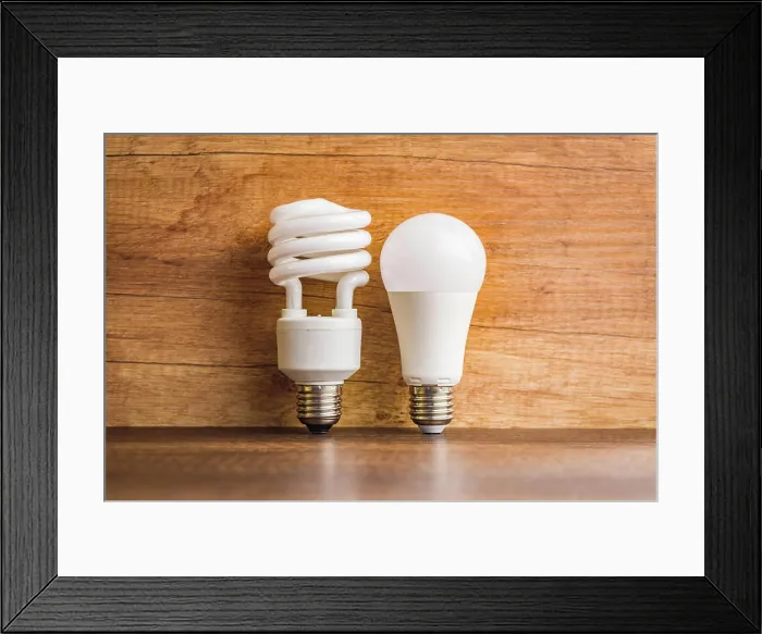 Framed Print : Energy saving light bulb. Fluorescent and led Lightbulb on wooden table Framed Print : Energy saving light bulb. Fluorescent and led Lightbulb on wooden table