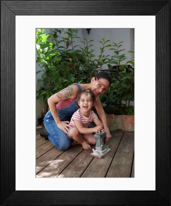 Framed Print : mother and daughter look at the camera sanding the wood on the floor Framed Print : mother and daughter look at the camera sanding the wood on the floor