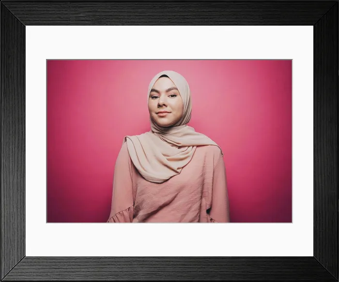 Framed Print : Portrait of confident young woman wearing hijab against pink background Framed Print : Portrait of confident young woman wearing hijab against pink background