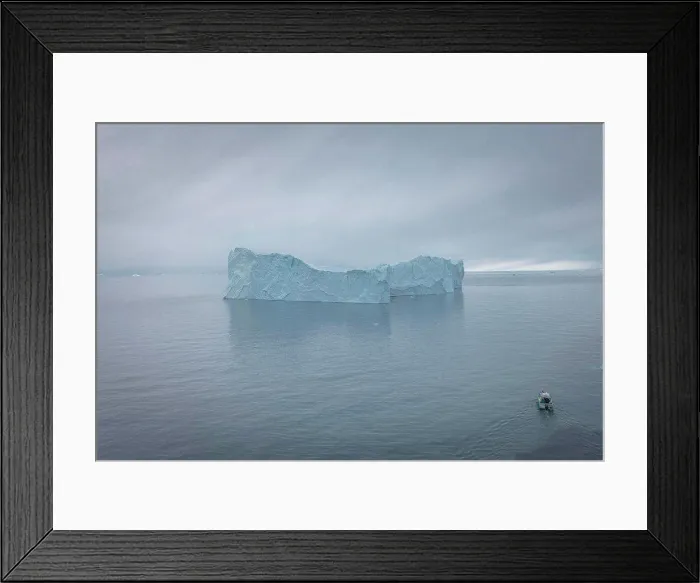 Framed Print : small boat sailing in front of extreme icebergs from aerial view
