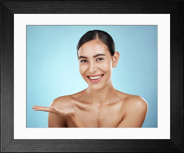 Framed Print : Portrait, beauty skincare and woman with product placement in studio isolated on a blue background Framed Print : Portrait, beauty skincare and woman with product placement in studio isolated on a blue background
