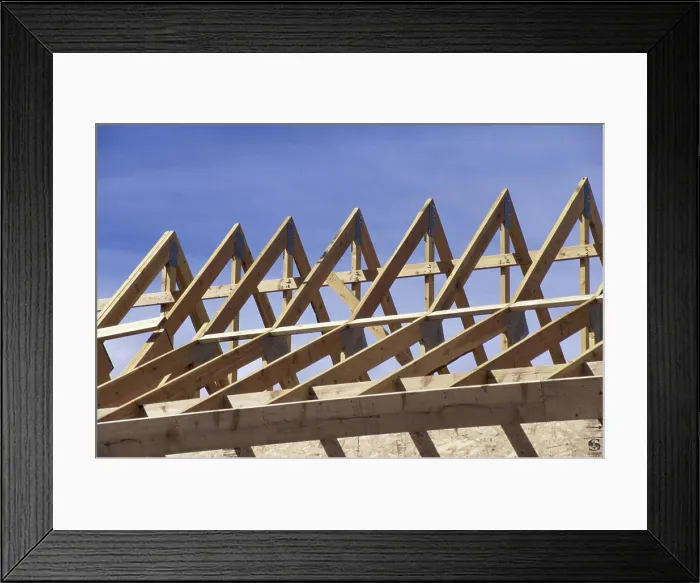 Framed Print : Wooden framework of a roof of a house under construction Framed Print : Wooden framework of a roof of a house under construction