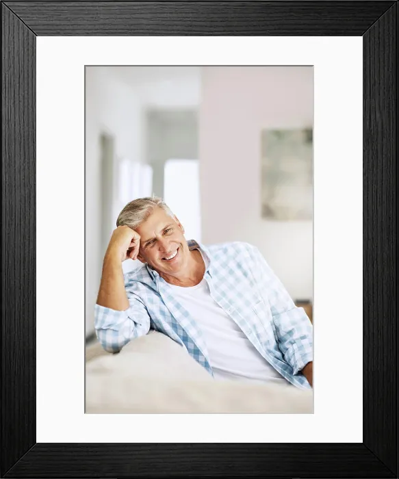 Framed Print : Casual, relaxed and happy mature man smiling indoors on his couch at home on a relaxing day Framed Print : Casual, relaxed and happy mature man smiling indoors on his couch at home on a relaxing day