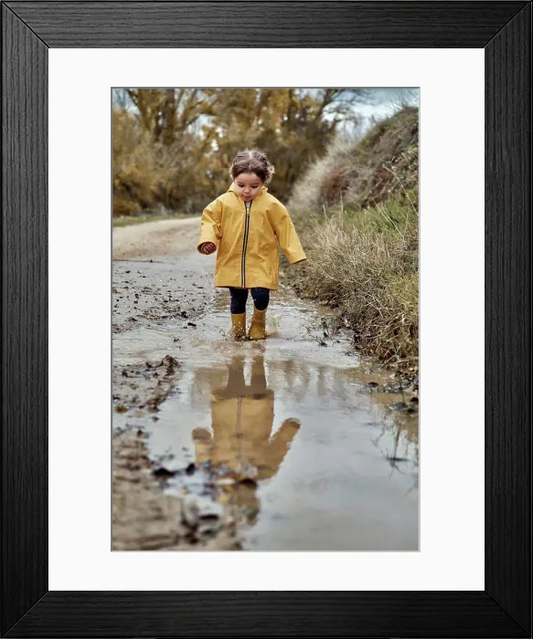 Framed Print : A 2 year old girl playing with a mud puddle Framed Print : A 2 year old girl playing with a mud puddle