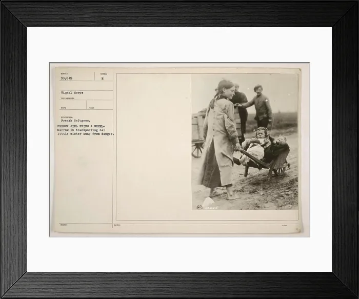Framed Print : French girl using a wheelbarrow to transport her little sister away from danger during World War One