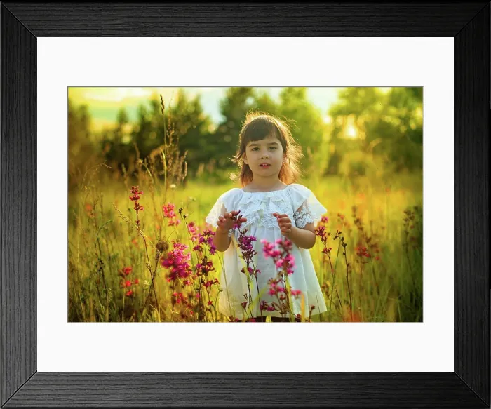 Framed Print : Ein kleines Mädchen im weißen Kleid steht allein im warmen Sonnenlicht in einem blühenden Feld A little cute girl Framed Print : Ein kleines Mädchen im weißen Kleid steht allein im warmen Sonnenlicht in einem blühenden Feld A little cute girl