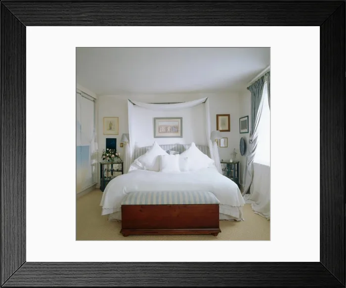 Framed Print : Chest below bed with white linen and drapes in white bedroom Framed Print : Chest below bed with white linen and drapes in white bedroom