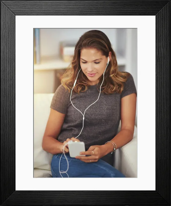 Framed Print : Woman, earphones and streaming music on couch