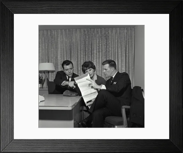 Framed Print : Vintage Photograph. A businessman and a couple sitting at a desk reviewing a credit contract Framed Print : Vintage Photograph. A businessman and a couple sitting at a desk reviewing a credit contract