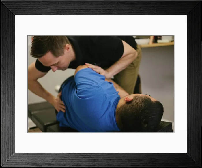 Framed Print : Patient receives a spinal adjustment at a chiropractic office