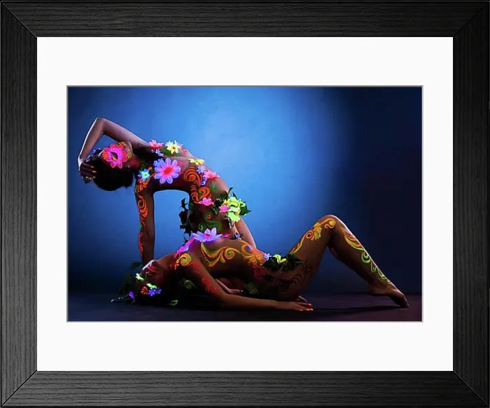 Framed Print : Couple of Naked women posing with glow ultraviolet body art and flowers Framed Print : Couple of Naked women posing with glow ultraviolet body art and flowers