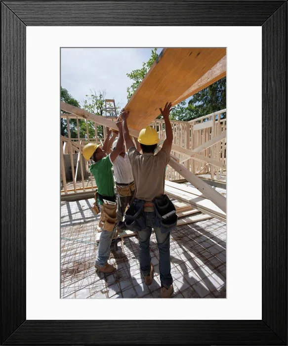 Framed Print : Carpenters lifting a laminated beam at a construction site Framed Print : Carpenters lifting a laminated beam at a construction site