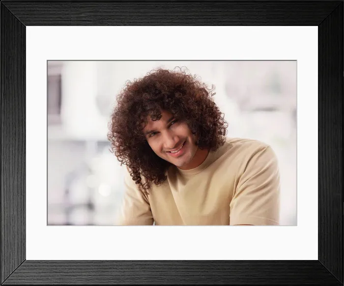 Framed Print : A MAN WITH CURLY HAIR HAPPILY SITTING AND LOOKING AT CAMERA