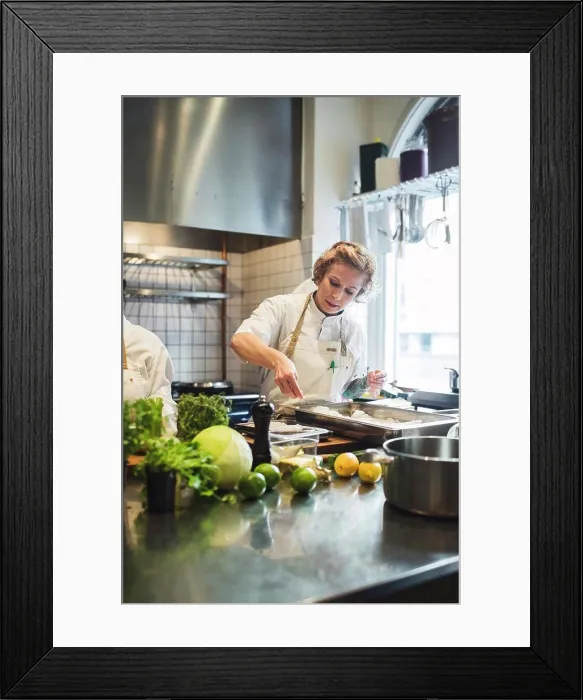 Framed Print : Female chef preparing food in tray at commercial kitchen Framed Print : Female chef preparing food in tray at commercial kitchen