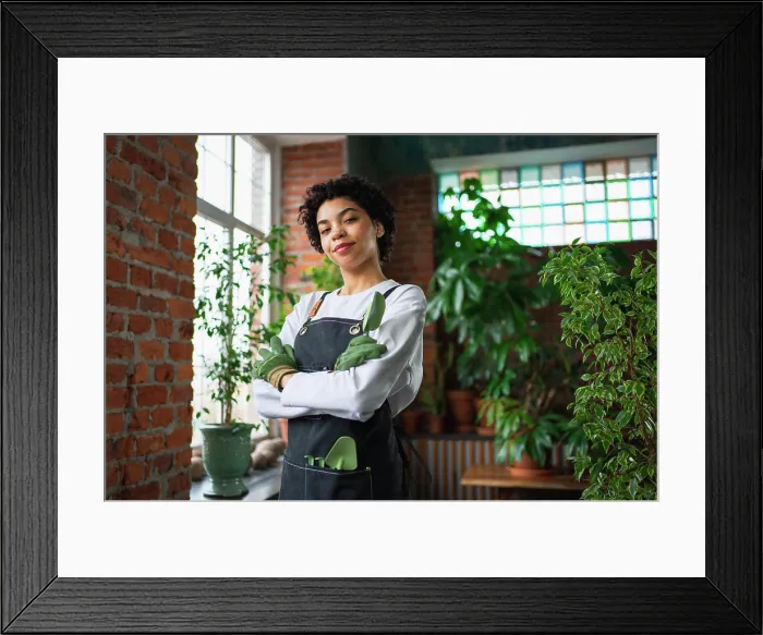 Framed Print : Running of own business. African woman florist wearing apron in botanical store with green plants Framed Print : Running of own business. African woman florist wearing apron in botanical store with green plants