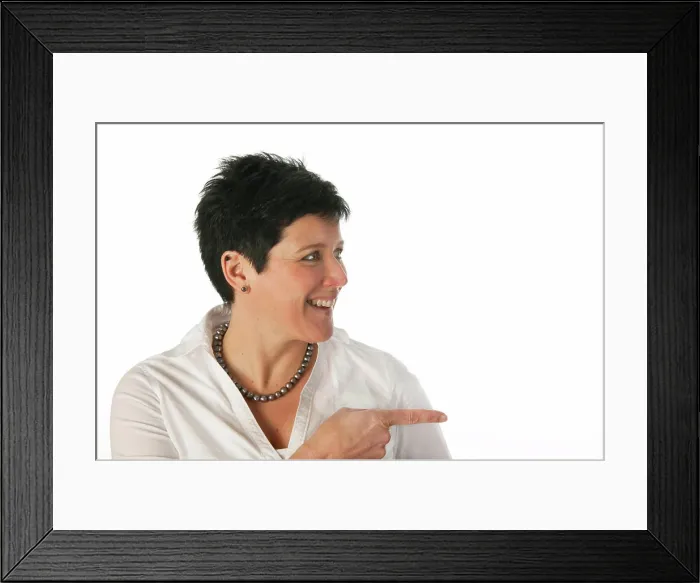 Framed Print : Young woman Young woman pointing to the right as studio portrait Framed Print : Young woman Young woman pointing to the right as studio portrait