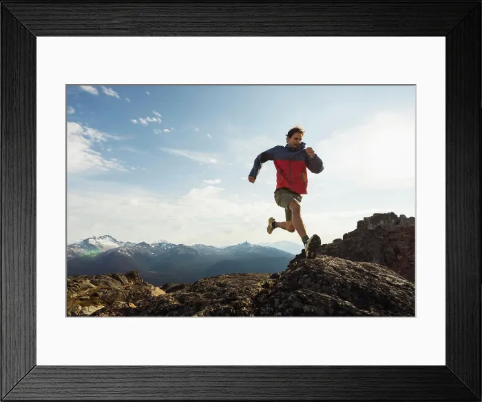 Framed Print : Trail runner in a red jacket navigating rocky mountain terrain